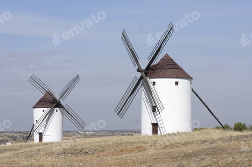 Preview: A Horizontal Shot Of Two White Mills In An Empty Field In Belmonte, Spain