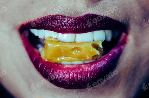 Preview: Close-Up Of Woman Mouth Biting Caramel Candy