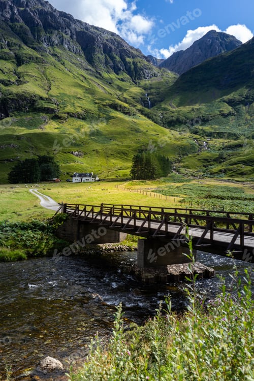 Preview: A Vertical Shot Of A Bridge Over The River Surrounded By The Mountains In Scotland