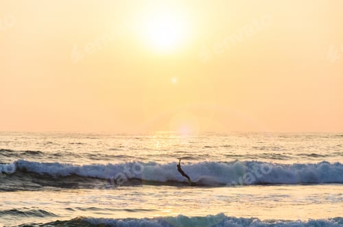 Preview: Surfing At Sunset. Young Man Riding Wave At Sunset. Outdoor Active Lifestyle.