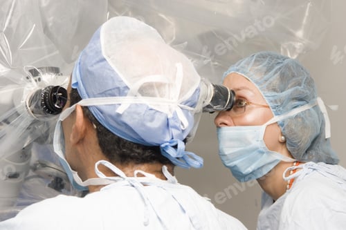 Preview: Group Of Surgeons Using Operating Microscope During Their Work