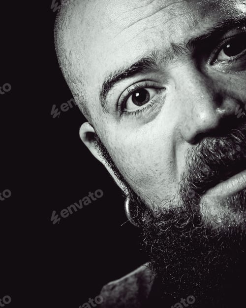 Preview: Black Background Studio Shot Of A Long-Bearded, Balding Hispster Man Sniffing With Amazement Or