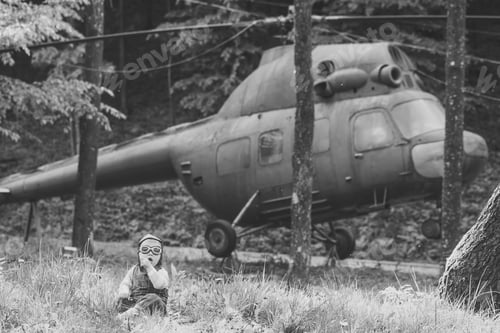 Preview: Travelling And Adventure. Boy In Pilot Helmet And Glasses Sitting In Green Grass. Happy Childhood