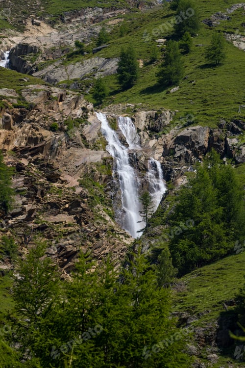 Preview: A Vertical Shot Of A Waterfall On The Mountains Captured In South Tyrol, Italian Alps