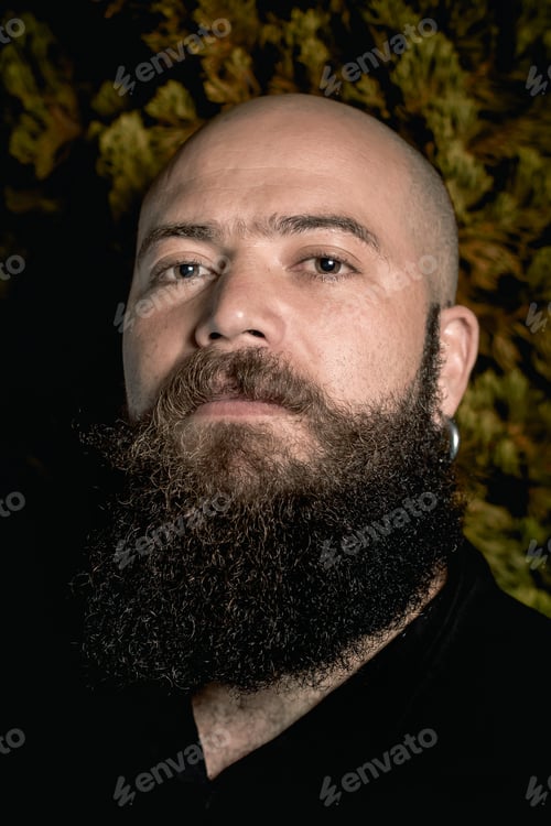 Preview: Somber-Looking Outdoor Photograph Of A Bald, Long-Bearded Hipster Stilo Man.