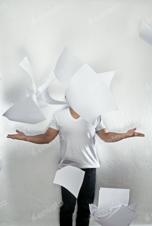Preview: Young Latino Bald Man In Studio With Papers Falling On His Face In A Stress Relief Situation.