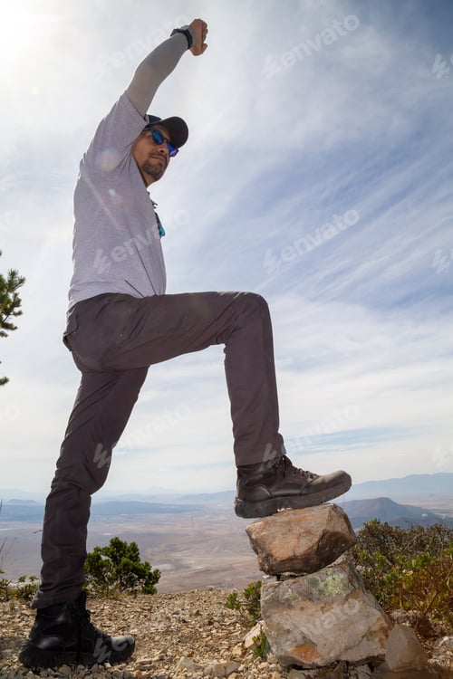 Preview: Low Angle Shot Of A Hiker Putting His Foot On A Rock Climbing A Mountain