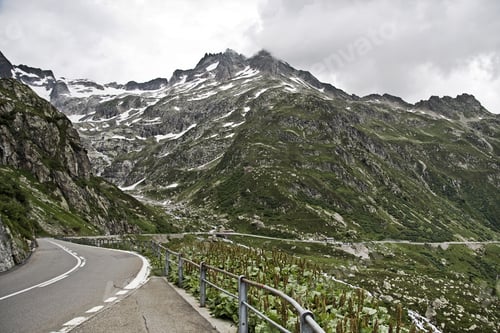 Preview: A Mesmerizing Scenery Of The Beautiful Road Among The Mountains Under A Cloudy Sky