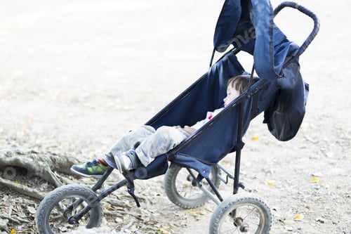 Preview: Lovely Boy Sleeping In Rolls Stroller In The Park