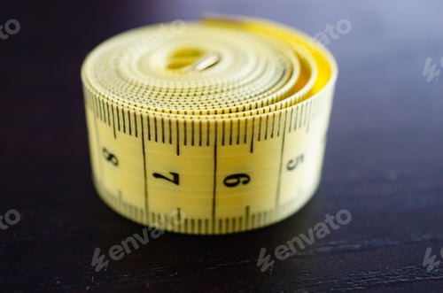 Preview: A Close Up Shot Of A Rolled Yellow Measuring Tape In Centimeters On A Wooden Surface