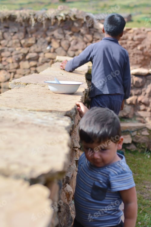 Preview: Empty Plate Put On The Wall And Two Kids Looking For Food. Concept Of Hunger.