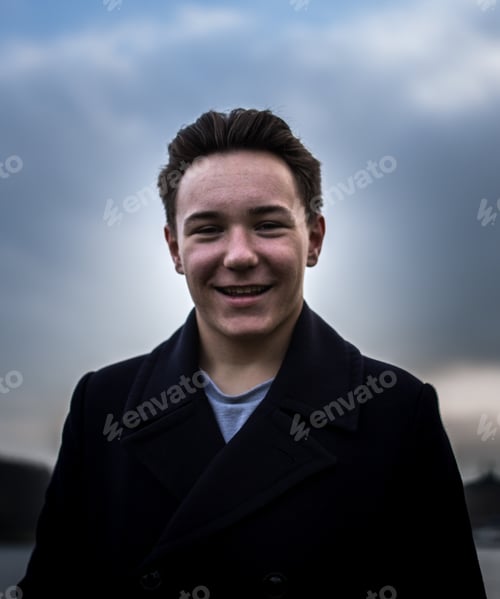 Preview: A Closeup Portrait Of A Positive Handsome European Man In An Overcoat Posing Outdoors