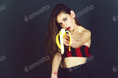 Preview: Woman with Banana in Studio with Dark Background