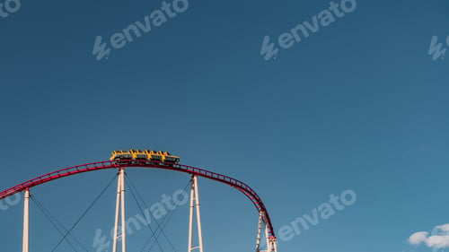 Preview: A Low Angle Shot Of A Roller Coaster Captured Under The Clear Blue Sky