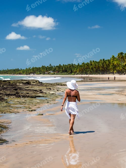 Preview: Attractive Woman Walking Along Beach With View On A Summer Day