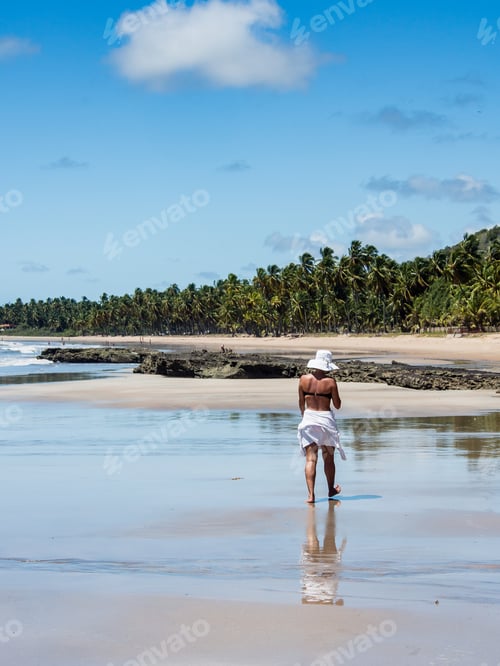 Preview: Attractive Woman Walking Along Beach With View On A Summer Day