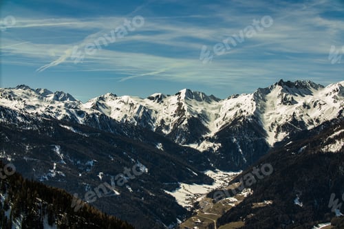 Preview: A Beautiful Scenery Of A Range Of Rocky Mountains Covered With Snow Under A Cloudy Sky