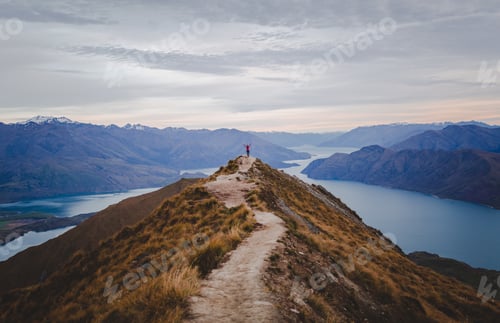 Preview: A Panoramic View Of The Roys Peak In New Zealand With Low Mountains In The Distance Under A Light