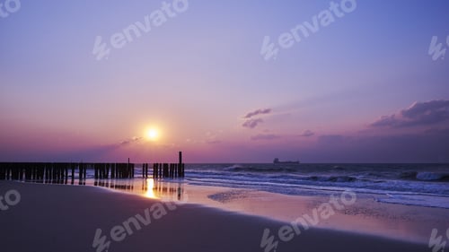 Preview: A Beautiful View Of The Sunset With Purple Clouds Over The Beach