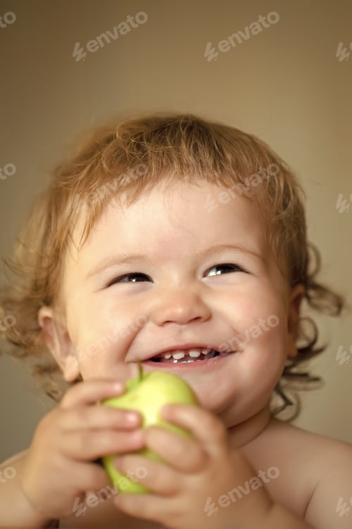Preview: Portrait Of Smiling Little Cute Male Kid With Blonde Curly Hair And Round Cheecks Holding One Green
