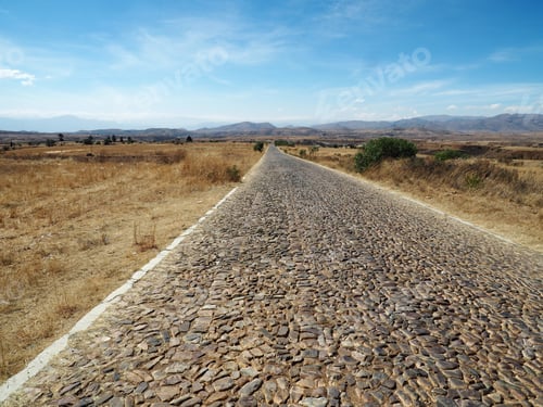 Preview: A Beautiful View Of A Narrow Road Under A Cloudy Sky