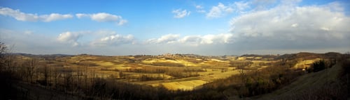 Preview: A Panoramic Shot Of Dry Grassy Fields With Trees Under A Blue Cloudy Sky At Daytime