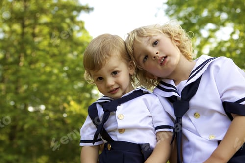 Preview: A Closeup Of Two Adorable Toddlers In Sailor Uniform Posing In The Park