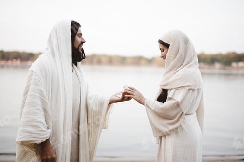 Preview: A Shallow Focus Shot Of Jesus Christ Giving A Piece Of Bread To A Female Wearing A Biblical Robe