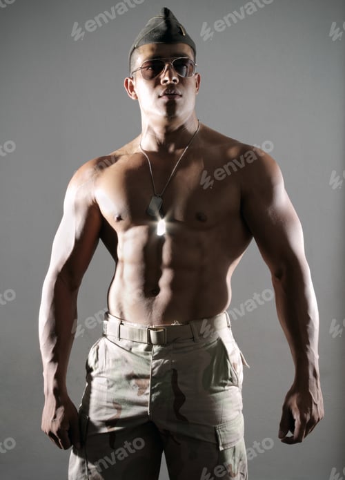 Preview: A Muscular Young Man In A Low Key Light With A Military Hat And Aviator Sunglasses.