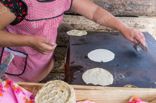 Preview: Closeup Shot Of A Woman In An Apron Preparing Traditional Mexican Tortillas On An Oven