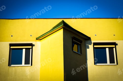 Preview: A Low Angle Shot Of A Yellow Building Under The Blue Sky