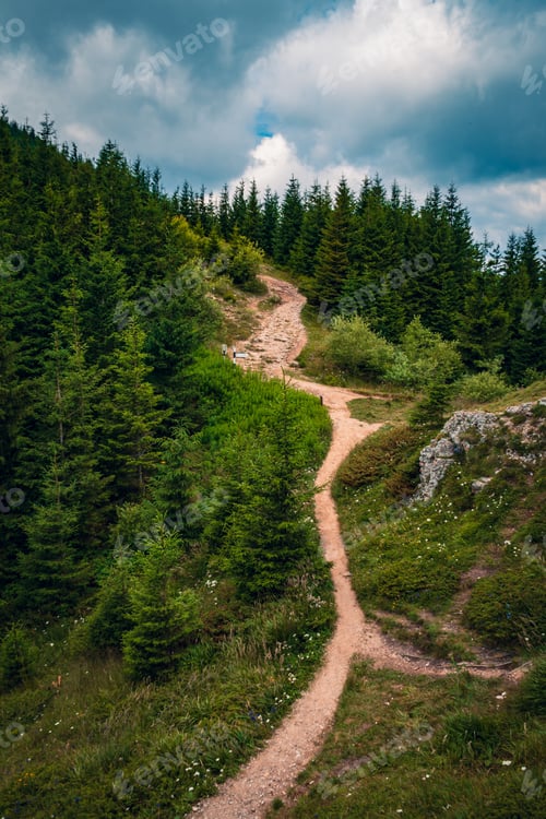 Preview: A Beautiful Scenery Of A Pathway On A Hill Surrounded By Greenery Under A Cloudy Sky