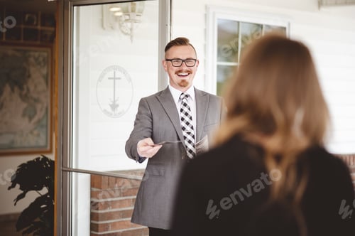 Preview: A Man In Suit Handing Out A Church Pamphlet To A Woman