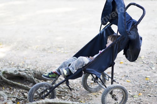 Preview: Lovely Boy Sleeping In Rolls Stroller In The Park