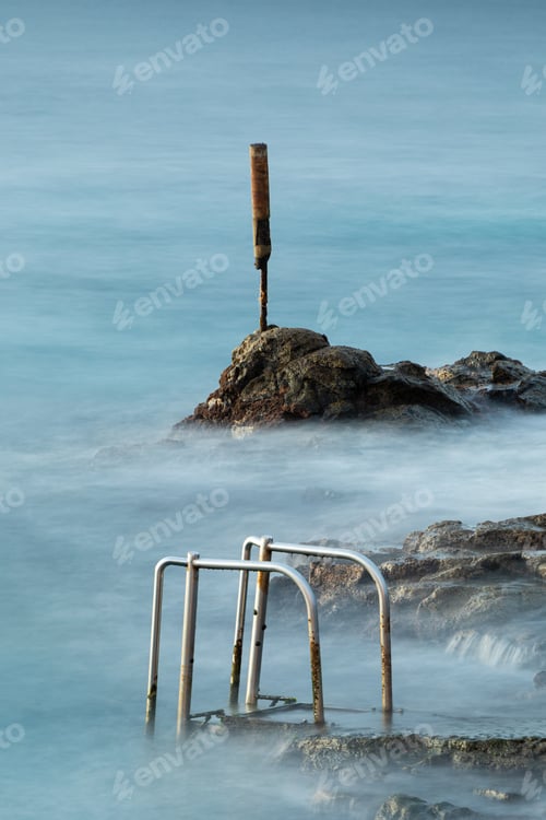 Preview: A View Of Rustic Handrailings Ion A Rocky Bay During High Tide