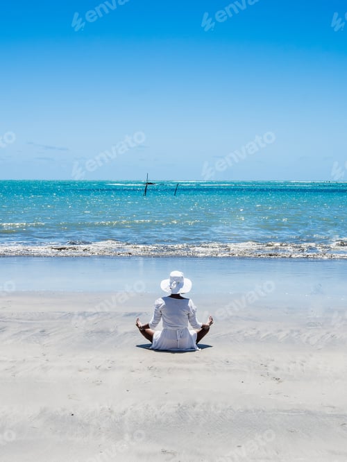Preview: Attractive Woman Meditating On Beach View On A Summer Day