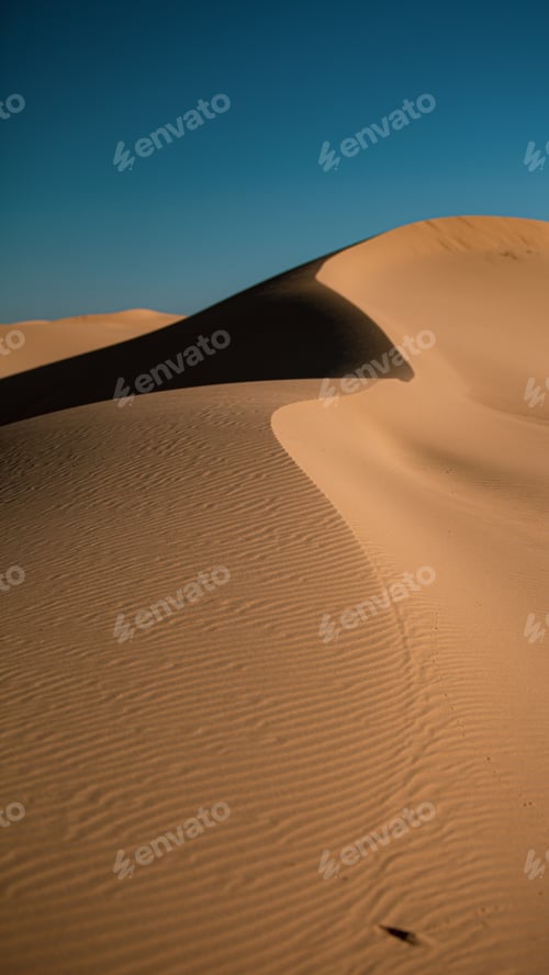 Preview: A Vertical Shot Of Sand Dunes In A Desert