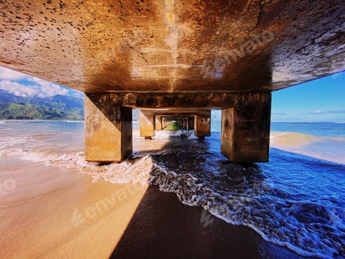 Preview: A Beautiful View Of The Ocean Waves Coming To The Sandy Beach Under The Pier