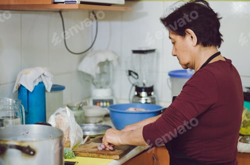 Preview: Senior Woman Preparing Healthy Home Food From Fresh Vegetables In Kitchen.