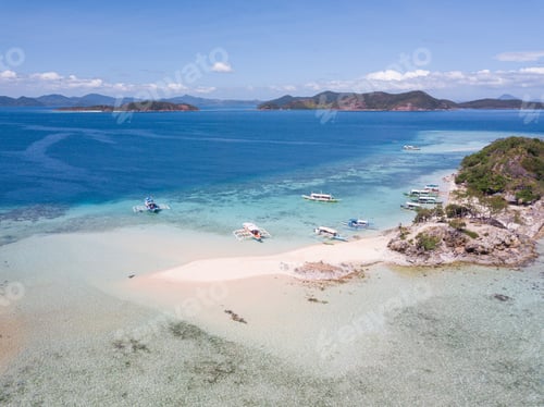 Preview: An Aerial Shot Of A Sandy Beach And A Few Boats In The Water With Some Greenery Around