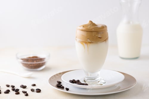 Preview: A Closeup Of A Glass Of Dalgona Coffee On The Table With Coffee Beans On It