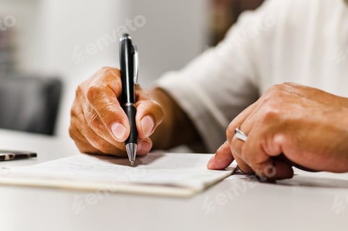 Preview: Close Shot Of A Human Hand Writing Something On The Paper On The Foreground .