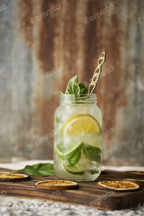 Preview: A Closeup Vertical Shot Of A Glass Jar Mojito Drink With Mint Leaves And Lemon Slices On A Wooden