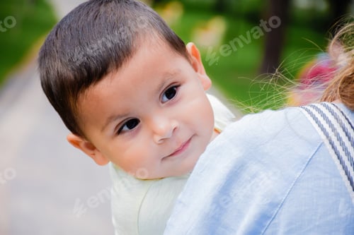Preview: Mother Holding Little Latin Boy With Content Facial Expression.