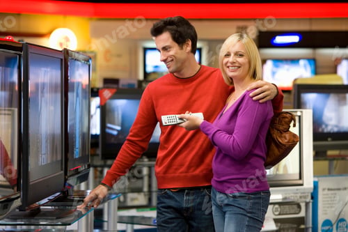 Preview: Young Couple Standing In The Middle Of An Electronics Appliances Store And Shopping For A New
