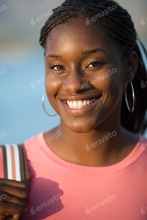 Preview: Vertical Head And Shoulder Portrait Of A Teenage Girl Smiling At The Camera On A Sunny Day.