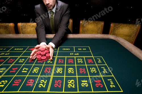 Preview: Poker Player Going "All In" Pushing His Chips Forward On The Roulette Table.