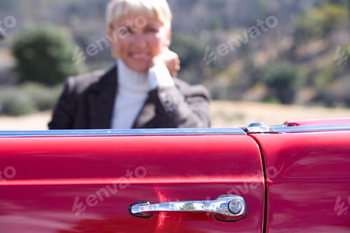 Preview: Selective Focus On Red Door Handle Of A Car With A Seated Senior Woman Posing Inside A Red
