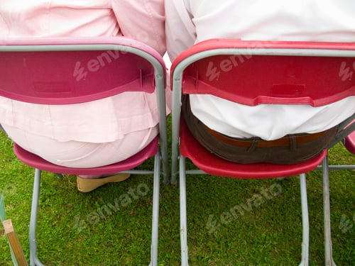 Preview: Back View Of The Couple Sitting Next To Each Other And Chatting In A Red And Pink Foldable Chair In