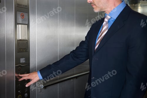 Preview: Close-Up Of Mid Section Of A Businessman Pressing Button In An Elevator.